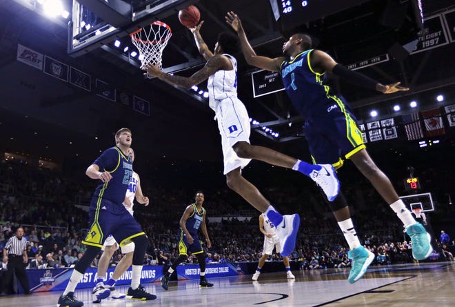 Duke guard Brandon Ingram, center, drives to the basket past North Carolina-Wilmington guard Chris Flemmings (1) during the first half in the first round of the NCAA college men's basketball tournament in Providence, R.I., Thursday, March 17, 2016. (AP Photo/Charles Krupa)