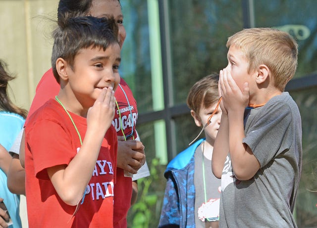 BRIAN D. SANDERFORD • TIMES RECORD Cavanaugh Elementary School second-grade students Daniel Brooks, left, and Ian Willis react as they detect one of the hidden stuffed animals at the Janet Huckabee Arkansas River Valley Nature Center on Wednesday, March 16, 2016. Students were tasked with finding as many as they could, but had to keep it a secret until Karen Westcamp-Johnson, education program specialist at the center, revealed all the locations.