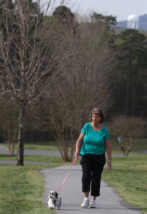 Patsy Buchanan walks her dog, "Maggie," along the walking trail Friday morning at the Gaston County Park in Dallas. MIKE HENSDILL/THE GAZETTE