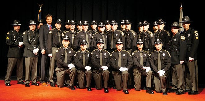 Worcester County Sheriff Lew Evangelidis is pictured with 21 new correction officers, including Leominster resident Officer Padraig Gilman, at the recent WCSO Graduation ceremony at Anna Maria College.