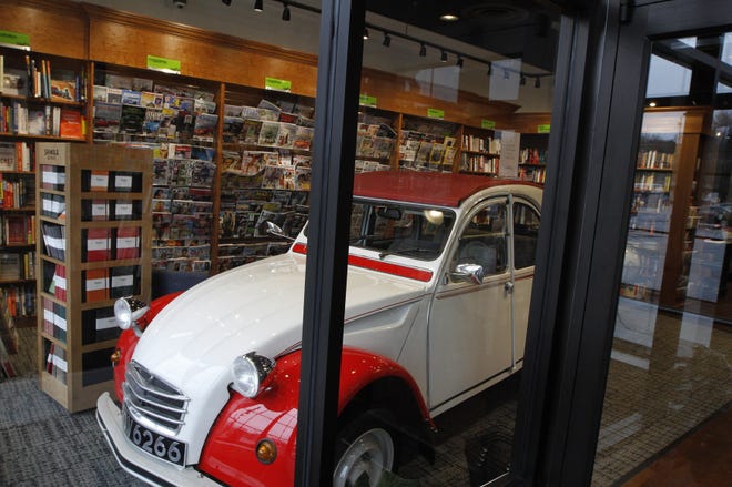 A vintage French-made Citröen is parked beside the periodicals at Barrington Books Retold in Cranston's Garden City shopping center. The Providence Journal/Kris Craig