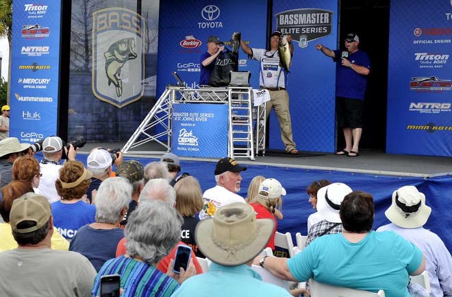 PETER.WILLOTT@StAugustine.com A Crowd watches on Palatka's riverfront as a fisherman holds up two fish he caught in the St. Johns River during the Bassmaster Elite fishing tournament on Friday, March 18, 2016.