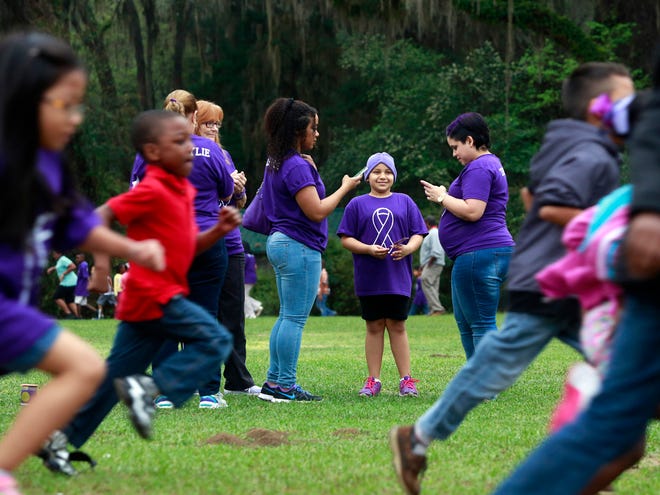 A pep rally and fun run are held at Idylwild Elementary School in Gainesvillein in honor of fourth-grade student Kylie Galloway-Soto, shown at center with her family, who was diagnosed with cancer.