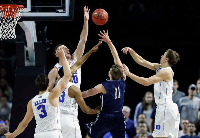 Duke's Marshall Plumlee, behind left, blocks a shot by Yale's Makai Mason, right, during the second half Saturday in Providence, R.I. Duke won 71-64.