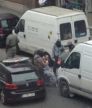 In this Friday, March 18, 2016 photo made available Monday March 21, an unidentified man believed to be connected to key suspect in the November 2015 Paris attacks Salah Abdeslam, is detained by police during a raid in the Molenbeek neighborhood of Brussels, Belgium. Abdeslam was arrested Friday March 18, in Molenbeek after a four-month manhunt, and investigators are known to be still hunting for other suspects on their wanted list. (AP Photo/Zouheir Ambar)