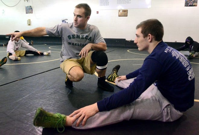 Seneca High School head wrestling coach, Greg Bauer talks with 170 lbs. wrestler, Nick Moore during a practice in 2012.