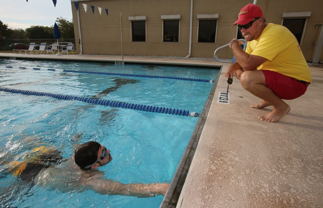 Mark Atkinson, a lifeguard instructor with Volusia County Beach Safety Ocean Rescue, worked Saturday with Joshua Brisebois during lifeguard tryouts in the Port Orange YMCA pool. News-Journal/NIGEL COOK