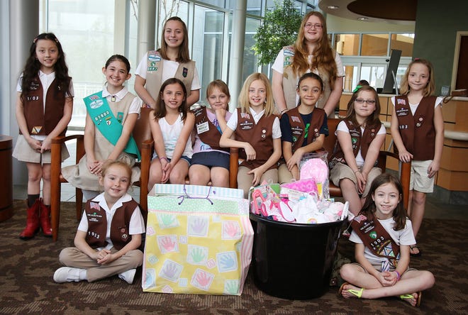 Girl Scout Troops 02528, 01903 and 02887 gathered at The Birthplace at CaroMont Regional Medical Center to present a baby basket to the family of the first baby girl born on March 12, the anniversary of the Girl Scouts of America. MIKE HENSDILL/THE GAZETTE.