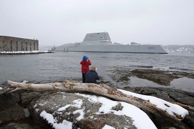 Dave Cleaveland and his son, Cody, photograph the USS Zumwalt as it passes Fort Popham at the mouth of the Kennebec River, Monday, March 21, 2016, in Phippsburg, Maine. A new destroyer, which was built at Bath Iron Works, will undergo final builder trials before the ship is presented to the Navy for inspection. (AP Photo/Robert F. Bukaty)
