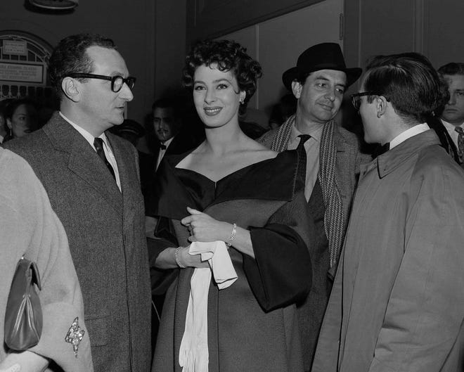 File photo - Actress Rita Gam in lobby of Longacre Theatre at opening of "The Burning Glass" March 4, 1954 in New York. At left is movie producer William Nelson, at right head turned, is Gam's husband Sidney Lumet. Man in hat is unidentified. (AP Photo/Ed Ford)
