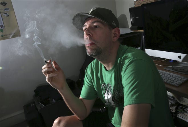 In this March 10, 2016, photo,f ormer U.S. Marine, Mike Whiter smokes marijuana before he starts editing a video project at his home in Philadelphia. A growing number of states are debating whether to legalize marijuana for the treatment of post-traumatic stress disorder. But for an increasing number of veterans, the debate is over. Theyíre using marijuana to alleviate PTSD-induced nightmares and anxiety, even itís banned by the federal government and remains illegal in their state. The trend raises questions about marijuanaís safety among a vulnerable group of veterans at a time when major studies have yet to prove the drugís effectiveness. (AP Photo/Mel Evans)