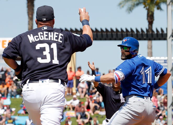 Detroit Tigers first baseman Casey McGehee (31) prepares to throw the ball to shortstop Jose Iglesias after they caught Toronto Blue Jays baserunner Kevin Pillar (11) in a rundown during a Grapefruit League spring training game at Joker Marchant Stadium in Lakeland.