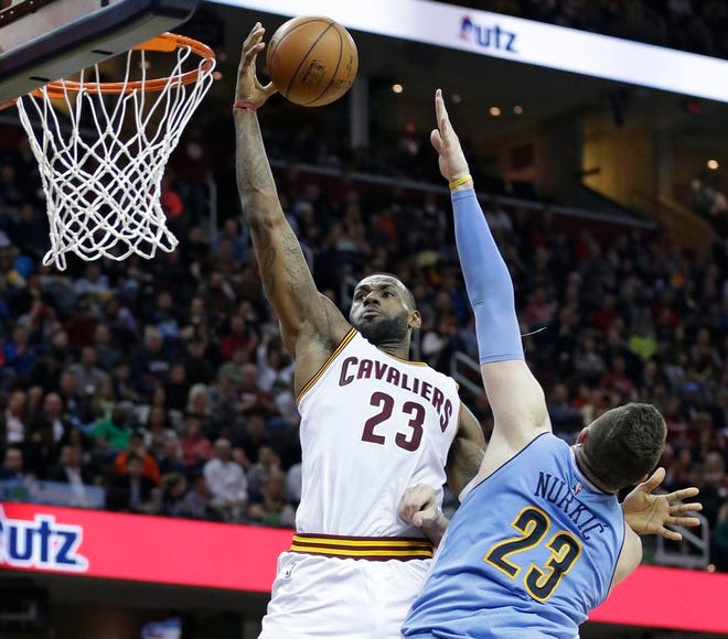 Cleveland Cavaliers' LeBron James, left, drives to the basket against Denver Nuggets' Jusuf Nurkic, from Bosnia Herzegovina, in the first half of an NBA basketball game Monday, March 21, 2016, in Cleveland.