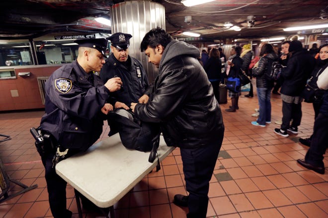 New York City Police Department Transit officers do a random bag check at the subway station under Grand Central Terminal, in New York, Tuesday, March 22, 2016. Authorities are increasing security throughout New York City following explosions at the airport and subway system in the Belgian capital of Brussels. (AP Photo/Richard Drew)
