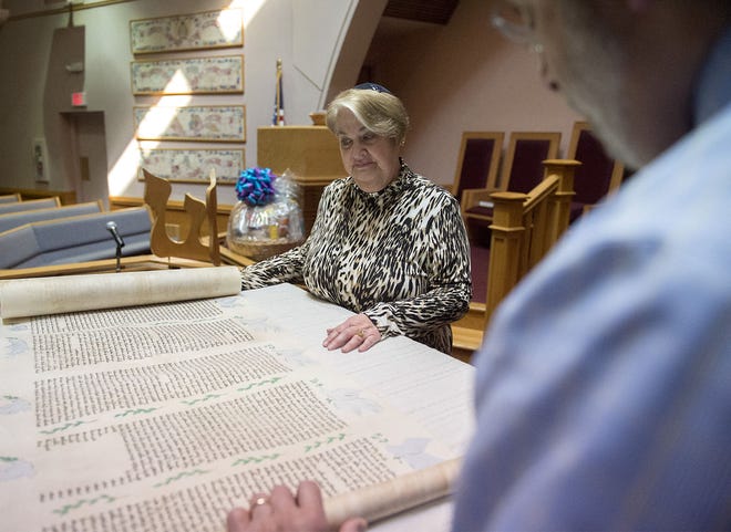 Idelle Wood of Philadelphia and Rabbi Eliott Perlstein show off a commissioned Megillah Book of Esther. Wood wanted to give back to the synagogue for what she called her "milestone birthday" this year, as the synagogue is also celebrating a "milestone birthday" of 40 years on the eve of Purim with a commissioned scroll.