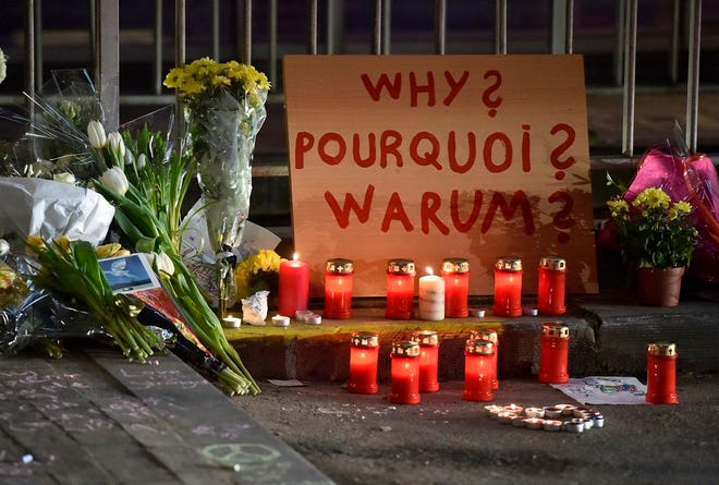 A sign reads "Why?" in English, French and Flemish behind candles and flowers near the Maelbeek metro station, in Brussels on Wednesday evening, March 23, 2016. Bombs exploded Tuesday at Brussels airport and one of the city's metro stations, killing and wounding scores of people, as a European capital was again locked down amid heightened security threats. (AP Photo/Martin Meissner) ORG XMIT: MME142