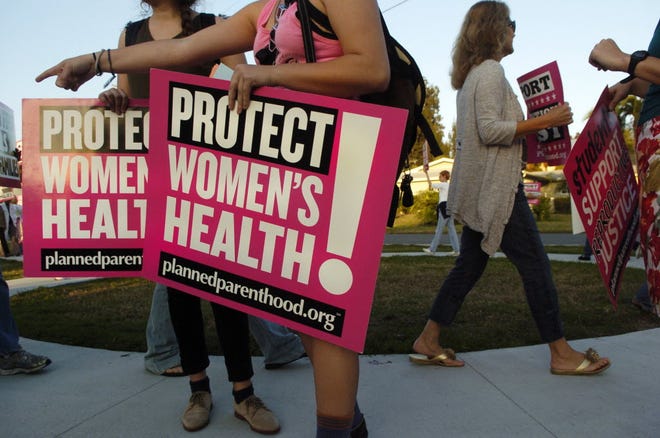 A rally is held in support of Planned Parenthood outside a meeting of lawmakers in Sarasota.