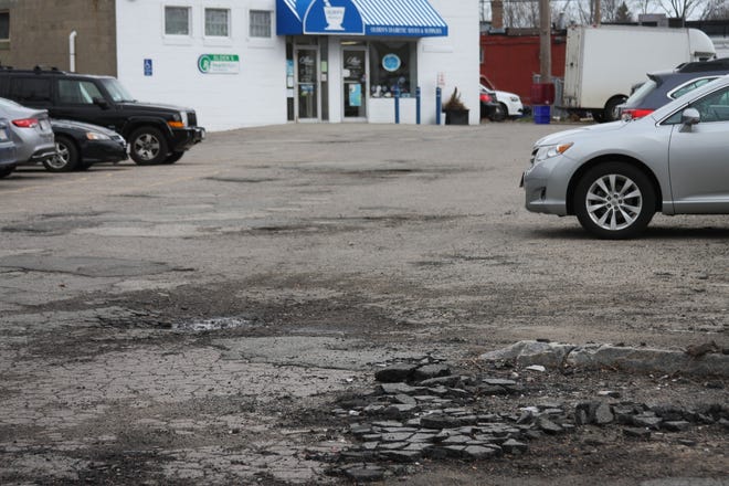 This municipal parking lot behind a row of stores in Columbian Square will have its potholes smoothed over during the weeks ahead. Wicked Local photo/ Bradford Randall