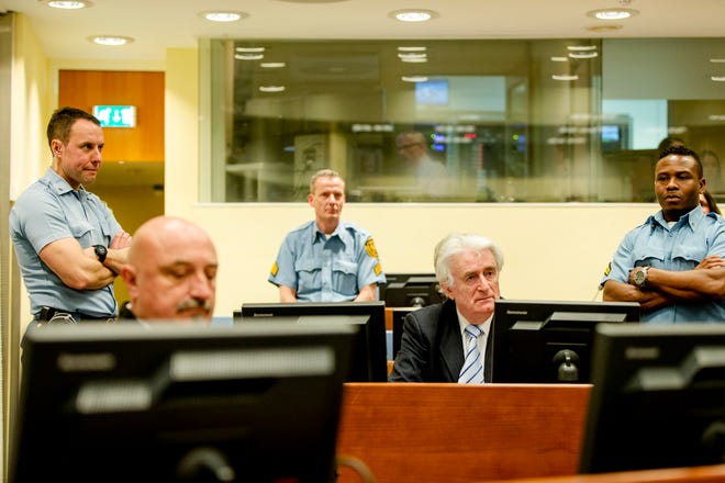 Bosnian Serb wartime leader Radovan Karadzic, second right, sits in the courtroom for the reading of his verdict at the International Criminal Tribunal for Former Yugoslavia (ICTY) in The Hague, The Netherlands Thursday. The former Bosnian Serb leader was sentenced to 40 years for genocide, crimes against humanity and war crimes.