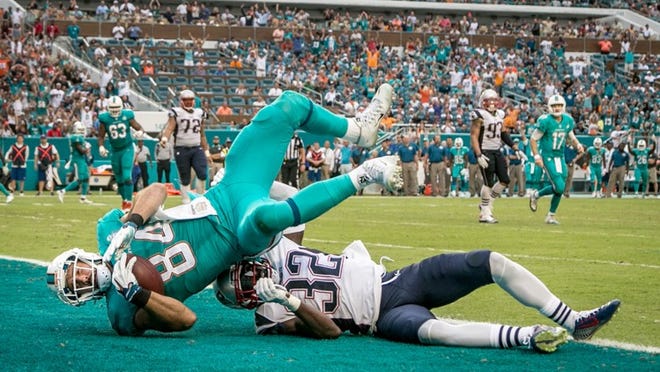 Miami Dolphins tight end Jordan Cameron (84) scores the go ahead touchdown on a pass completion defended by New England Patriots free safety Devin McCourty (32) at Sun Life Stadium in Miami Gardens, Florida on January 3, 2016. (Allen Eyestone / The Palm Beach Post)