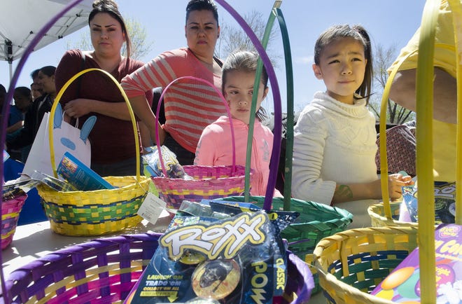 Children look over the Easter baskets being distributed by the Victor Valley Rescue Mission during their annual "Easter Egg-Stravaganza" at Center Street Park in Victorville on Wednesday. The event kicked off a series of Easter celebrations throughout the High Desert this weekend. James Quigg, Daily Press