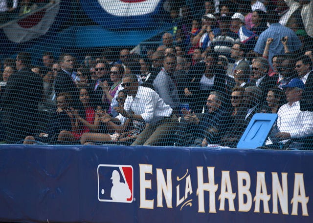 From front center: Cuban President Raul Castro, President Barack Obama, first lady Michelle Obama, Sasha Obama, and Malia Obama applaud during an exhibition game between the Cuban National team and the Major League Baseball Tampa Bay Rays in Havana on Tuesday. Eliana Aponte/Bloomberg