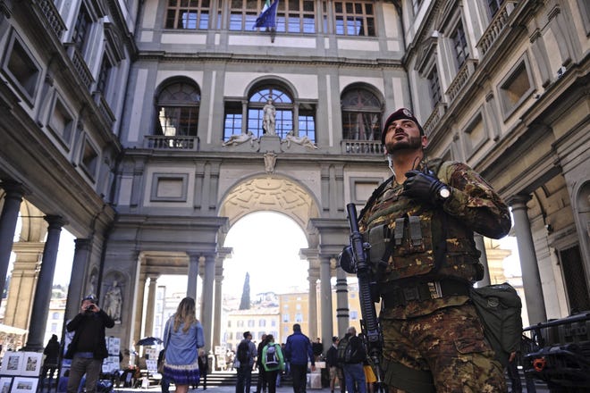 An Italian army soldier patrols in front of the Uffizi Gallery, in Florence's historical center, Italy, Friday, March 25, 2016. The Italian interior minister said 396 people had been arrested since the beginning of 2015 as part of anti-terrorism investigations, which included searches against 2,249 people suspected of religious extremism. (Maurizio Degl'Innocenti/ANSA via AP)