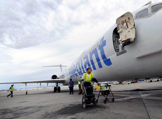 A ramp agent retrieves gate checked items after the Allegiant Air jet parked at McCarran International Airport in Las Vegas. Some airline safety advocates question whether Allegiant is showing signs of stress caused by its rapid growth.