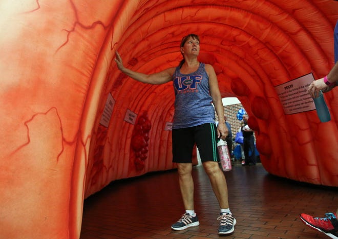 Nurse Andrea McIntosh educates her family about colorectal cancer as she walks through a inflatable colon at UF Health Shands Hospital on Friday, March 25, 2016. UF Health is helping raise awareness for colon cancer and the importance of regular screenings all month.
