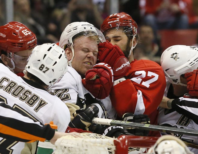 Pittsburgh Penguins' Patric Hornqvist, of Sweden, tangles with Detroit Red Wings' Kyle Quincey (27) around the net during the first period of an NHL hockey game Saturday, March 26, 2016, in Detroit. (AP Photo/Duane Burleson)