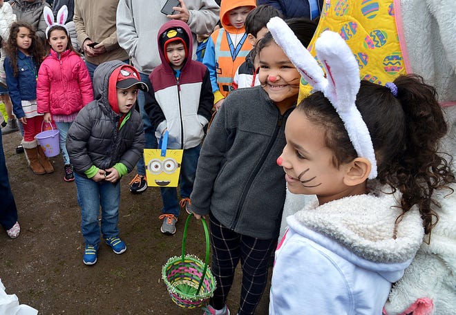 Children pose with the Easter bunny during the 25th annual Easter Egg Hunt at Ghiloni Park in Marlborough Saturday. According to organizers, 22,000 plastic eggs containing a total of 70,000 pieces of candy were up for grabs. The event is sponsored by the Marlboro Fraternal Order of Eagles.

Daily News Staff Photo/Ken McGagh