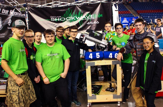 Dover High School's Shockwaves team stands with their robot during the FIRST Robotics Competition in Durham on Saturday. Photo by AJ St.Hilaire/Fosters.com