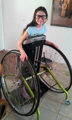 CONTRIBUTED Haleigh McKee, a 12-year-old Gamble Rogers Middle School student battling Hashimoto's encephalopathy, puts her new stander to the test on March 14, 2016. The rare autoimmune disease rendered McKee unable to walk after symptoms started showing in September. The stander allows her to get around by using the wheels with her hands while building up strength in her body to hopefully walk again.