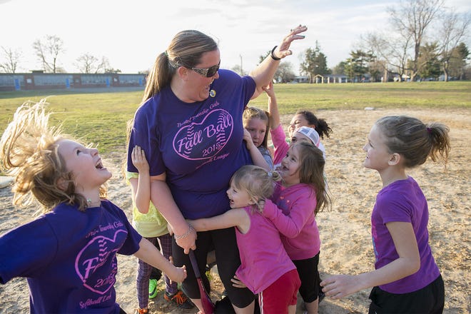 Girls on the 5- to 8-year-old teams of the Bristol Township Girls Softball League hug coach Dawn Horwitz during practice at fields behind John Fitch Elementary School in Bristol Township on Wednesday, March 23, 2016.