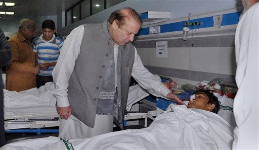 In this photo released by Press Information Department, Pakistan's Prime Minister Nawaz Sharif talks to an injured victim of Sunday's suicide bombing during his visit to a local hospital in Lahore, Pakistan, Monday, March 28, 2016. Pakistan’s prime minister on Monday vowed to eliminate perpetrators of terror attacks such as the massive suicide bombing that targeted Christians gathered for Easter the previous day in the eastern city of Lahore, killing 70 people. (AP Photo/Press Information Department via AP)
