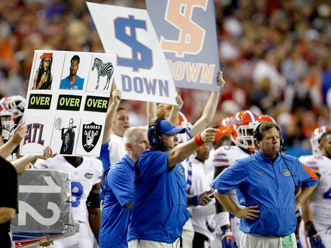 Florida coach Jim McElwain, right, is making a tad more in pay than he did at his first job.