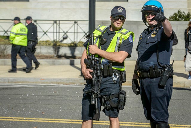 Police, some with assault rifles, patrol the scene outside of the U.S. Capitol building after an intruder was shot by Capitol police, on Monday in Washington. Bill O’Leary/The Washington Post