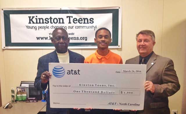 Rep. George Graham, left, joined John Lyon, AT&T regional director for external affairs, right, to present Chris Suggs, founder of Kinston Teens, with a $1,000 contribution for the expansion of leadership development program.