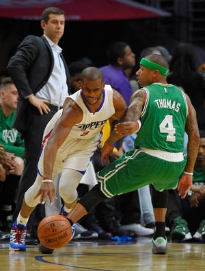 Clippers guard Chris Paul drives past Celtics guard Isaiah Thomas as Celtics head coach Brad Stevens watches during Los Angeles' win at Staples Center Monday night.