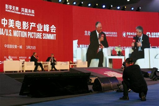In this Friday, March 25, 2016 photo, Dick Cook, left, chairman of Dick Cook Studios, interviews Alfonso Cuaron, director of science fiction movie "Gravity" and keynote speaker, at the China-U.S. Motion Pictures Summit in northern China's Hebei province. Film Carnival, a private film company in eastern China, announced Wednesday, March 30, 2016 that it has agreed to invest at least $500 million in the studio of former Walt Disney boss Dick Cook to make movies to be distributed worldwide. (AP Photo/Louise Watt)