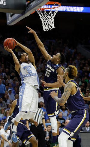 North Carolina's Marcus Paige, left, goes up for a shot against Notre Dame's Bonzie Colson, center, and Zach Auguste during the second half of a regional final men's college basketball game in the NCAA Tournament, Sunday, March 27, 2016, in Philadelphia. (AP Photo/Chris Szagola)