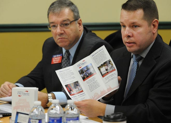 Kris Bartley, president of the Fall River charter review group, shows a brochure for the group's effort to get questions on the review and on making a nine-member commission on the November 2015 ballot during a Herald News editorial board meeting. Behind him is City Councilor Mike Miozza, who's also involved with the group.