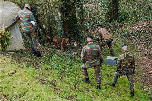 Soldiers search a wooded area in Marke, Belgium, Thursday, March 31, 2016. Authorities are searching a wooded, residential area close to the French border amid reports that the action is linked to the recent arrest of a man in Paris suspected of planning an attack. (AP Photo/Geert Vanden Wijngaert)