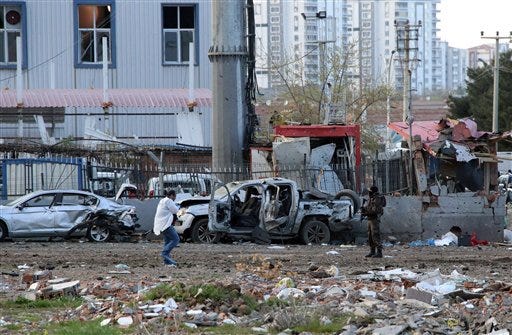 Security and forensic officials work at the site after an explosion caused by a bomb-laden car targeting police in the mainly Kurdish city of Diyarbakir, Turkey, Thursday, March 31, 2016, Turkish news agencies reported. The explosives detonated as a vehicle carrying special forces and riot police passed by, causing many deaths and injuries. (AP Photo/Mahmut Bozarslan)