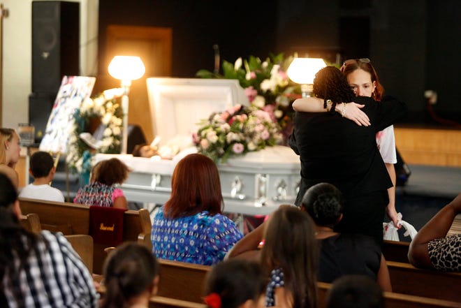 Jennifer Appel, right, legal guardian of Robert Dentmond Jr., who was shot and killed by local law enforcement officers, is consoled by loved ones while attending Dentmond's funeral service at Ignite Life Center in Gainesville Thursday.