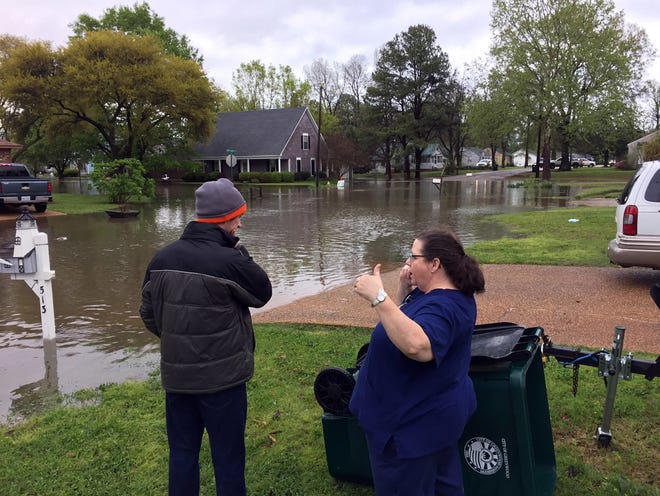 Lisa Ramsey, right, says in seven years at her West Jeff Davis Avenue home she's never seen the water so high as it got, Thursday, March 31, 2016, in Greenwood, Miss., as Justin Carpenter joins her in surveying the scene. The National Weather Service said Greenwood received 5 inches of rain between 1 a.m. and 5 a.m. Thursday. Greenwood and Leflore County schools and Pillow Academy were closed because of flooding-related problems on Thursday. (Tim Kalich/The Greenwood Commonwealth via AP)