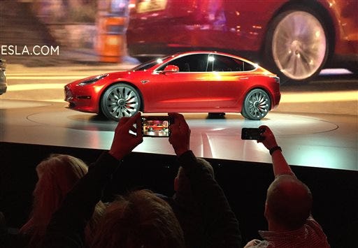 CORRECTS SPELLING OF PHOTOGRAPHER'S LAST NAME TO PRITCHARD, NOT PRICHARD - Tesla Motors unveils the new lower-priced Model 3 sedan at the Tesla Motors design studio in Hawthorne, Calif., Thursday, March 31, 2016. It doesn't go on sale until late 2017, but in the first 24 hours that order banks were open, Tesla said it had more than 115,000 reservations. Long lines at Tesla stores, reminiscent of the crowds at Apple stores for early models of the iPhone, were reported from Hong Kong to Austin, Texas, to Washington, D.C. Buyers put down a $1,000 deposit to reserve the car.