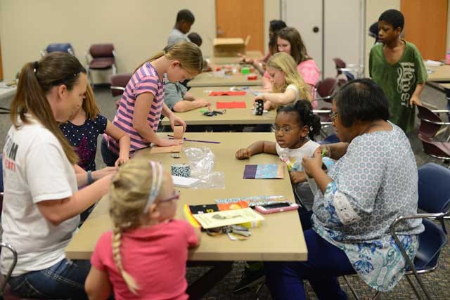 The auditorium is filled with library patrons creating story books, pencil holders and more as they celebrate spring break on Wednesday at the Kinston-Lenoir County Public Library.