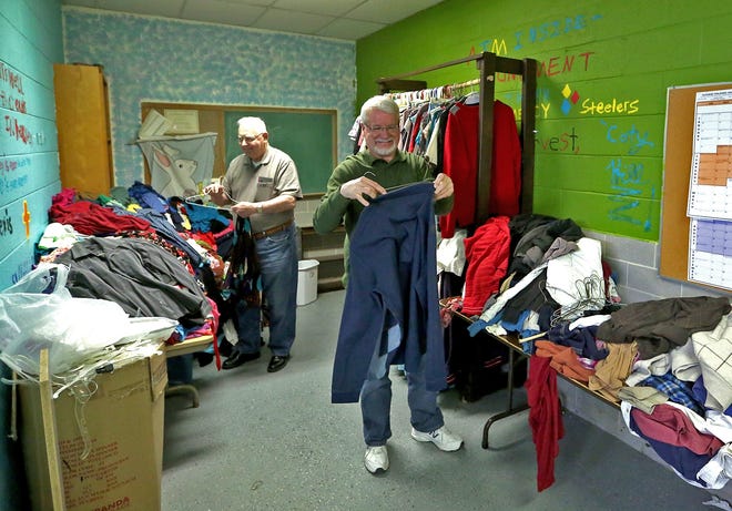 Times-Reporter/Jim Cummings

Uhrichsville Nazarene Church clothing closet volunteer Laurell Burdette and Pastor Mike Travis put clothes on hangers recently in the shop.