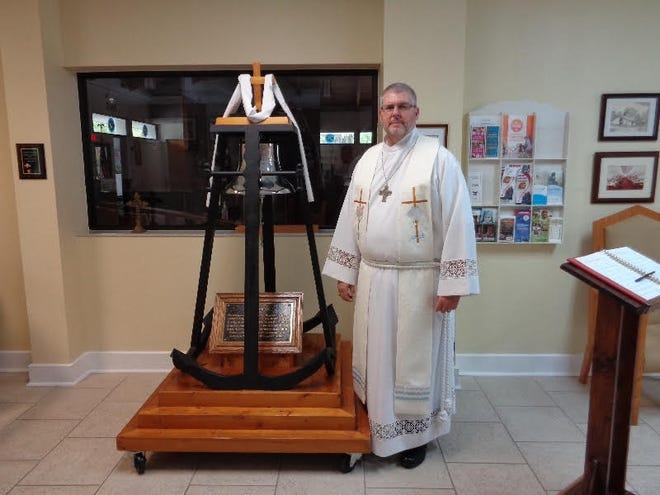 St. Mark by the Sea Lutheran Church Pastor Vincent Iocona stands beside the church bell that once tolled aboard a U.S. Navy destroyer during World War II. The bell now is used to call congregants to services at the Palm Coast church. NEWS-TRIBUNE/DAVID VARNER